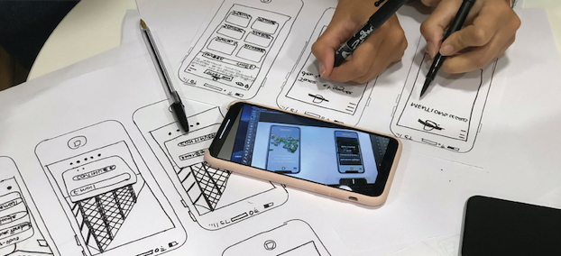 Students drawing prototypes of phone apps by hand.